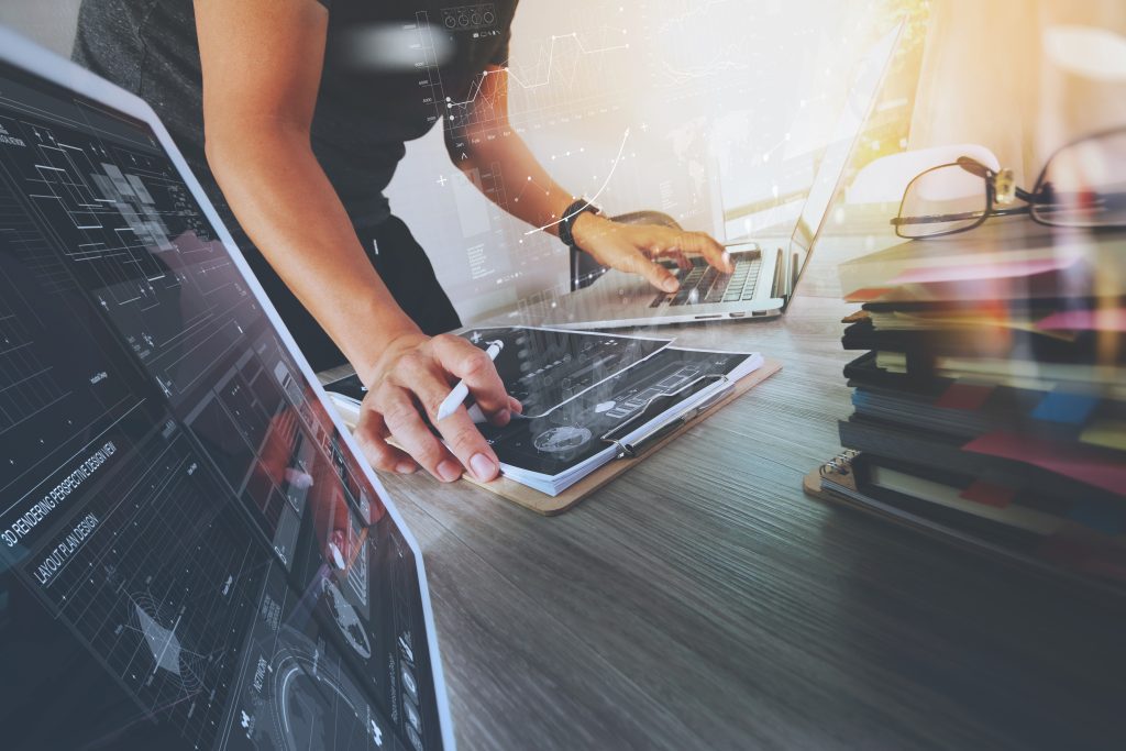 Website-Designer arbeiten mit digitalem Tablet und Computer-Laptop