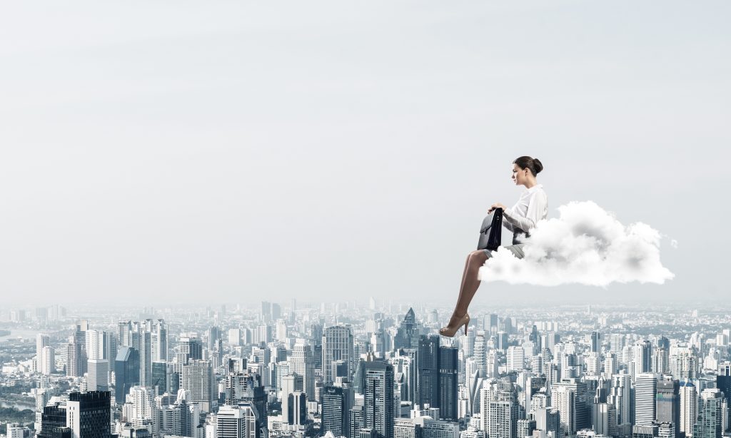 Geschäftsfrau oder Buchhalterin auf einer Wolke, die hoch über einer modernen Stadt schwebt