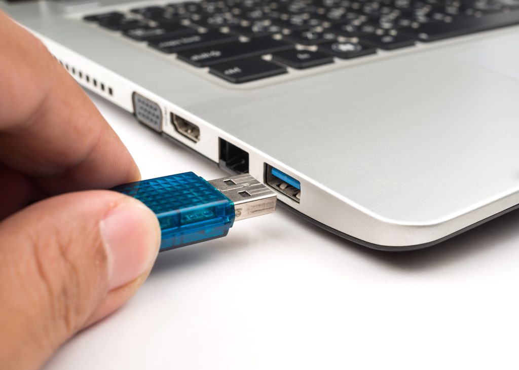 Blauer USB wird in Laptop gesteckt