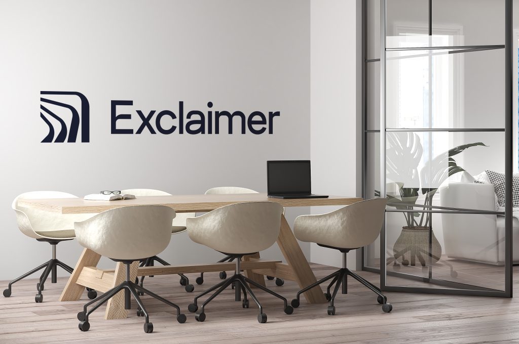 Ein hochmodernes Büro, hell mit bedruckter Wand. Inschrift auf der Wand lauet "Exclaimer"